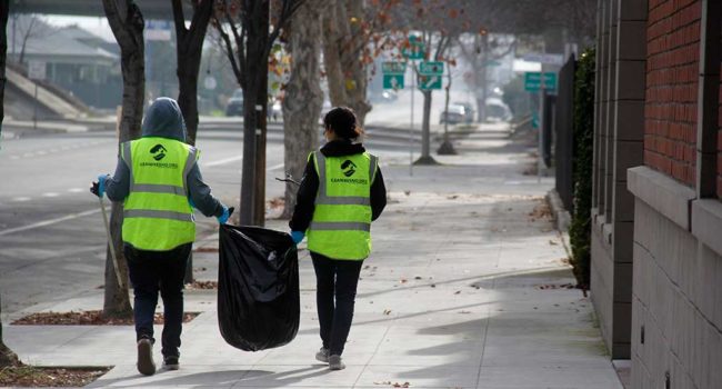 Two volunteers picking up trash.